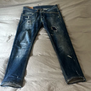 Blå slitna jeans från Dondup - Säljer ett par blå jeans från Dondup med slitningar dom är helt nya perfekt till sommaren dom är ganska tunna pris går att diskutera 