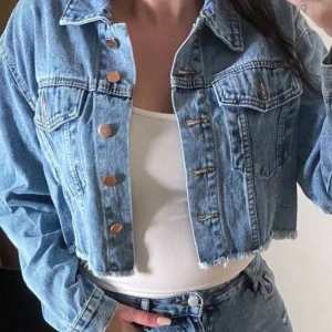 Croppad jeansjacka med knappar - Säljer en croppad jeansjacka i ljusblå denim.