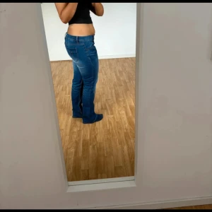 Blå bootcut jeans med låg midja - Säljer ett par blå jeans med bootcut-modell och låg midja. Jättesnygga lågmidjade jeans