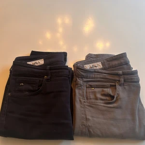 J.Lindeberg jeansbyxor slim fit 32/34 - Två par snygga jeansbyxor från J.Lindeberg i storlek 32/34. Ena paret är svart och det andra är grått, båda med klassisk femficksdesign och metallogo på fickan. Slim fit-modell med smal siluett och stretchigt bomullsmaterial för skön passform. Om du bara vill köpa ett par jeans är det bara att skicka.