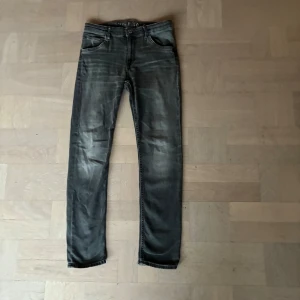 Svarta jeans med smal passform - Snygga svarta jeans med diskret tvättad look och klassiska fem fickor. Jeansen har smal passform och raka ben, samt dekorativa sömmar på bakfickorna. Perfekta till en avslappnad stil. 