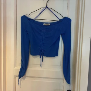 Långärmad tröja - Fin blå långärmad tröja med knyt på båda ärmsluten och vid magen, så man kan göra den kortare än på bilden om man vill!