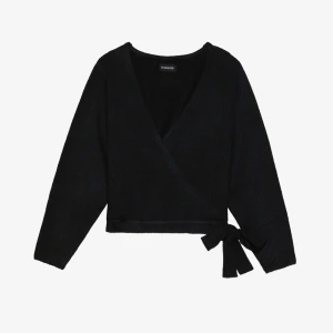 Svart omlottopp med knyt från even&odd - Svart omlottopp från even&odd med lång ärm och knyt i sidan. Toppen har v-ringning och är croppad, vilket ger en trendig look. Stickad i mjukt material som passar perfekt till jeans eller kjol.