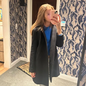 Kappa New house  - Svart kappa från new house som jag fick i julklapp förra året☺️ endast använd en gång så i nyskick. strl xs! (Passar en xs/s) den har luva och fickor. Nypriset är 4000kr💕