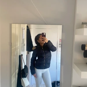 Svart pufferjacka med fuskpäls - Stilren varm och skön jacka 