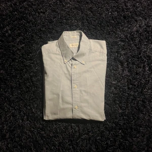 Ljusblå skjorta från These Glory Days - Snygg ljusblå skjorta från These Glory Days i slim fit-modell. Skjortan har klassisk krage och knäppning framtill. Perfekt för dig som gillar stilrena och enkla plagg. Tillverkad i mjuk bomull för en skön känsla hela dagen.