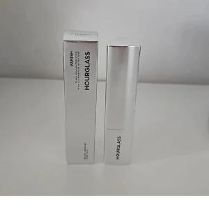 Hourglass Vanish Highlighter Stick - Hourglass Vanish Flash Highlighting Stick i färgen Champagne Flash. Kommer i en snygg, silvrig hylsa med trekantig form. Ger en krämig, skimrande finish som smälter in i huden för en glowig look. Perfekt att använda direkt på kindben, näsrygg och amorbåge.