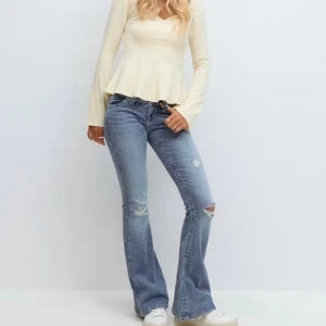 Blå bootcut jeans med broderade fickor - Snygga ljusblå bootcut jeans med slitningar på knäna och broderade bakfickor med paljetter. Säljer då dem är lite små men endast använda få gånger! Helt utan defekter, därför priset, men går att diskutera. 💕