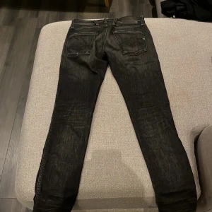 Svarta Replay jeans skinny fit - Säljer ett par svarta Replay jeans med skinny passform. Jeansen har klassisk femficksdesign, svarta sömmar och Replay-logga på fickan. Materialet är stretchigt jeans och färgen har en lätt tvättad look för en cool vibe.