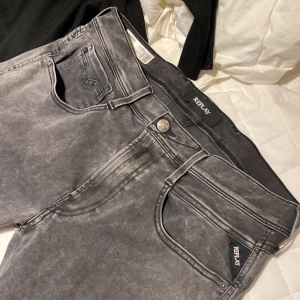 Replay svarta jeans W33 L32 slim fit  - Säljer ett par svarta Replay jeans med tvättad look och smal passform. Klassisk femficksmodell med Replay-logga på fickan och metallknapp i midjan. Jeansen är i stretchigt material för extra komfort. Aldrig använt 