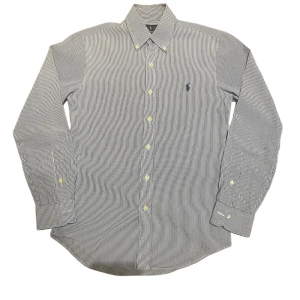 Randig skjorta från Ralph Lauren XS -  Storlek: XS Färg: Vit / Blå Skick: 8/10 (litet ej synligt hål på baksidan) Passform: Slim Fit Material: 100% bomull 📦Skickar så fort som möjligt. Skriv om du har frågor.