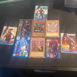 Samling av Fortnite-, Yu-Gi-Oh!- och fotbollskort alla för 200kr - Perfekt för dig som gillar gaming, fantasy och sport! Här får du en mix av Fortnite-kort, Yu-Gi-Oh!-monster och fotbollsstjärnor som Messi, Foden och Dembélé. Samlingen passar både samlare och dig som vill ha coola kort att byta med vänner.