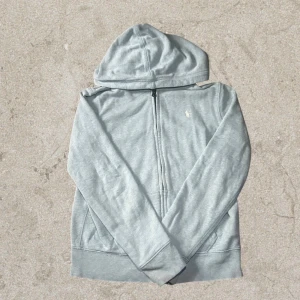Ralph lauren zip hoodie - 💎 Superfin Ralph Lauren zip hoodie 💎 Storlek 152 (barn) 👕 Färg: Ljusblå 💙 – stilren, fräsch och passar till allt!  🔥 Jättebra skick – nästan som ny, inga fläckar eller slitage ✨ Perfekt för höst/vår 🍂🌸 eller som mysig hoodie året runt 😍  🦋 Klassisk Ralph Lauren-stil med loggan framtill – både bekväm och snygg 👌 💨 Dragkedja framtill & mjukt material för extra komfort!  📦 Skickas snabbt  💙 Passa på innan den försvinner! 💙