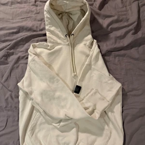 Beige hoodie från Jack & Jones - Säljer en beige hoodie från Jack & Jones i storlek M. Tröjan har huva med snörning, ribbade muddar och en stor magficka. Mjuk insida i fleece som gör den extra skön. Perfekt för chill dagar och enkel att matcha med jeans eller joggers. Använd ca 6 gånger.