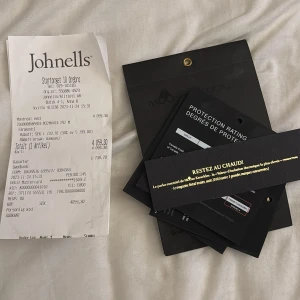 Montreal pufferjacka från Moose Knuckles - Säljer en Montreal pufferjacka från Moose Knuckles i svart. Jackan har en modern och stilren design med värmande isolering, perfekt för kalla dagar. Märkets logga finns på detaljerna och jackan har praktiska fickor och dragkedja framtill.