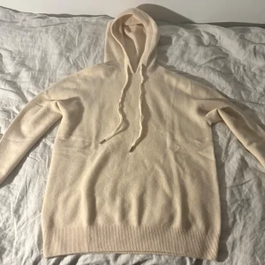 Grisch beige Hoodie - Helt ny aldrig använd. Supermjuk beige hoodie med huva. Tröjan är ribbad i nederkant och vid ärmslut, vilket ger en snygg passform. Tillverkad i kashmirblandning för en lyxig och skön känsla. Perfekt för mysiga dagar och chill outfits.