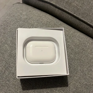 AirPods Pro - Säljer ett par AirPods Pro i mycket fint skick, komplett med originalförpackning, manualer och extra öronkuddar. Laddningsfodral och hörlurar är rena och välbevarade, inga synliga repor eller skador. Perfekt för trådlös musik och samtal med aktiv brusreducering. Laddare ingår kp för fler bilder 