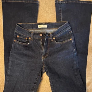 Lowwaist jeans - Lågmidjade mörkblåa jeans från Gina Tricot💙Mid/lowwaisted:) Mått finns (se bilder), ena bilden går inte att se hela måttet men från midjan till längst ned vid foten är hela 100cm lång💗Gissar på att innerbenslängden är ca 80cm. Storlek 34, alltså XS. De är köpta för 499kr, men använda ett par gånger och fortfarande i mycket bra skick, säljs nu för 200kr. Vid mer info osv hör gärna av dig🫶🏼🫶🏼