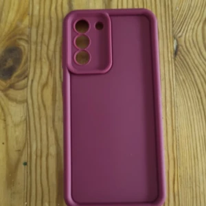 Samsung Galaxy S21 skal - Snyggt vinrött silikonfodral till Samsung Galaxy S21. Ger bra skydd mot repor och stötar, med exakt passform för kameran och knappar. Skalet är i fint skick utan synligt slitage eller defekter. Perfekt för dig som vill ge din mobil ett nytt utseende och extra skydd.