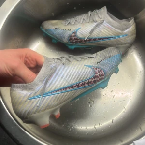 Nike Air Zoom Mercurial fotbollsskor - Säljer ett par Nike Air Zoom Mercurial Elite fotbollsskor. Dubbarna är för gräsplan främst. Använda men har mycket kvar att ge. Notera slitage på skosnören, går att till andra snören. 