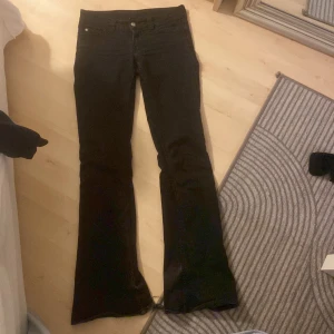 Svarta bootcut jeans Cheap Monday 26/32 - Svarta jeans från Cheap Monday i lowwaist och bootcut-modell med klassisk femficksdesign. rosa Cheap Monday-logga bak och är tillverkade i en bomullsblandning med stretch. Perfekta för dig som gillar en retro vibe och markerad siluett. Lite slitna i benen 