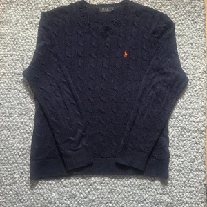 Kabelstickad Polo Ralph Lauren - En stilren kabelstickad tröja från Polo Ralph Lauren perfekt för nu när det börjar bli kyligt. Finns inga defekter eller skador. Tveka ej med att kontakta vid ytterligare frågor!