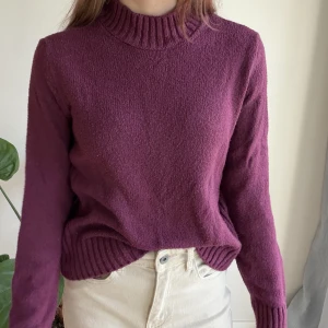 Vinröd stickad tröja från Lefties S - Vinröd stickad tröja från Lefties med ribbad hög hals, muddar och nederkant. Tröjan har en klassisk rak passform och är perfekt för lager-på-lager. Mjuk och skön, passar dig som gillar en enkel men snygg look.