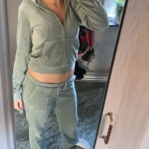 Mintgrön Juicy Couture hoodie och byxor  - Säljer en mintgrön hoodie från Juicy Couture i mjuk velour. Tröjan har dragkedja framtill, huva, långa ärmar och fickor. Klassisk broderad JC-logga på bröstet. Perfekt för chill dagar och snygg att matcha med mjukisbyxor.Ett skönt mjukis sätt män samtidigt så snyggt.Det är i barnstormer 12-13 