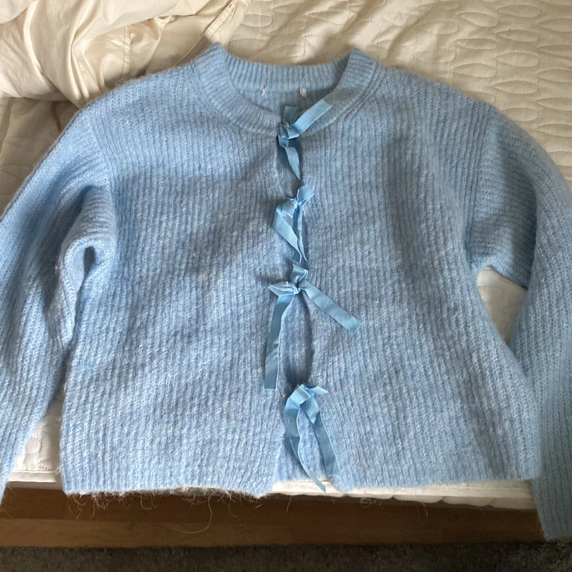 Ljusblå kofta med rosetter - 1