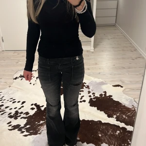 Svarta bootcut jeans från Gina Tricot - Säljer ett par svarta bootcut jeans från Gina Tricot med slitningar vid knäna och stora framfickor. Jeansen har låg midja, dubbla knappar och dragkedja. Jag är ungefär 160cm lång. Jag har använt byxorna minst 2 gånger och jag känner bara att de inte är för mig, köpte för 350-400. Pris går att diskuteras🫶🏼