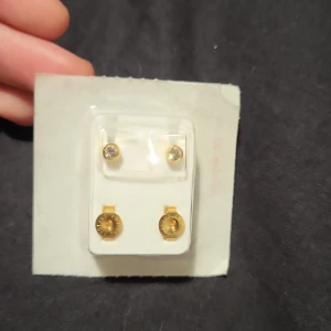 Guldörhängen från Caflon - Säljer ett par guldörhängen från Caflon. De är helt nya och fortfarande i sin förpackning. Perfekta för att ge en elegant touch till din outfit. Förpackningen är certifierad steril och örhängena är i nyskick.