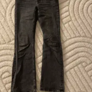 Svarta bootcut jeans med knäppen på bakfickorna Använda ganska mycket men i bra skick