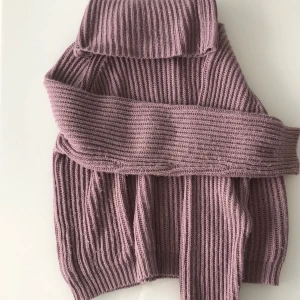 Lila stickad polotröja - Säljer en supermysig lila stickad polotröja. Den är perfekt för kalla dagar med sin höga krage och långa ärmar. Tröjan är ribbad och har en lös passform som gör den extra bekväm. Perfekt för höst och vinter! 💜