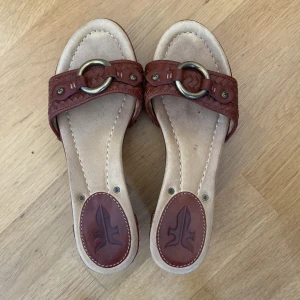 Frye sandal med kilklack - Klackhöjd 7,5 cm, total längd 23,5 cm. Storlek är ca 37.  Jättefina frye sandaler i läder med gummisulor. De är i fint skick.  Varning för att de är rätt smala och kanske inte passar om man har bredare fötter!  Skriv och fråga för fler detaljer💕