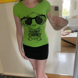 Grön t-shirt med tryck från Fishbone - Säljer en cool grön t-shirt från Fishbone i storlek XS. Den har ett roligt tryck av en sköldpadda med texten 'Turtley Nerdy'. Perfekt för vardagsbruk eller en avslappnad dag ute. T-shirten är i bra skick, använd några gånger och väldigt bekväm att ha på sig. Passar perfekt till jeans eller kjol!