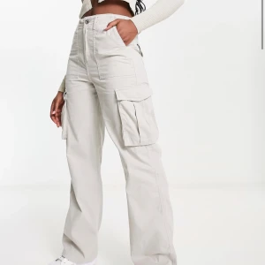 Beige cargopants - Säljer ett par snygga beige cargopants. De har hög midja och en loose passform. Byxorna har flera fickor, inklusive stora sidofickor, vilket ger dem en cool och praktisk look. Perfekta för en avslappnad och trendig stil!