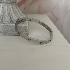 Armband i titan  - Nytt snyggt armband med stjärnmönster i titan. Okänt märke.