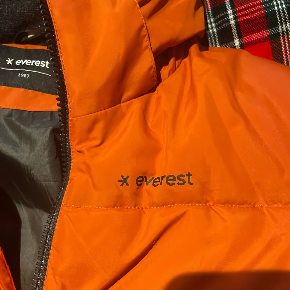 Säljer en snygg och varm orange pufferjacka från Everest som är använt ett par gånger! .Jackan har en dragkedja framtill och två fickor med dragkedjor. Den är perfekt för kalla vinterdagar och håller dig varm och bekväm. Jackan är i bra skick och redo för en ny ägare! Finns ingen skada på jackan! . Jackor.