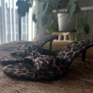 Leopardmönstrade sandaler från Zara - Säljer ett par snygga leopardmönstrade klackskor från Zara i storlek 38. De har en öppen tå och en liten klack, perfekt för fest. Sandalerna är i välanvänt skick men fortfarande väldigt trendiga och bekväma. Perfekta för en somrig dag eller en utekväll!🤎🖤🐆