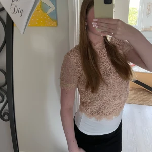 Beige spetsblus från Zara Trafaluc - Säljer en superfin beige spetsblus från Zara Trafaluc, perfekt för vår och sommar! Blusen är kortärmad och croppad med en dragkedja i ryggen. Den har ett vackert spetsmönster som ger en romantisk touch. Använd ett par gånger men har inga defekter på sig. Passar perfekt till både fest och vardag! Tveka inte på att skriva om ni undrar något!