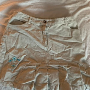 Secondhand kjol - Beige kjol med blå detalj, köpt på secondhand för 130kr. Storlek 170. Säljes för den ej kommer till användning 