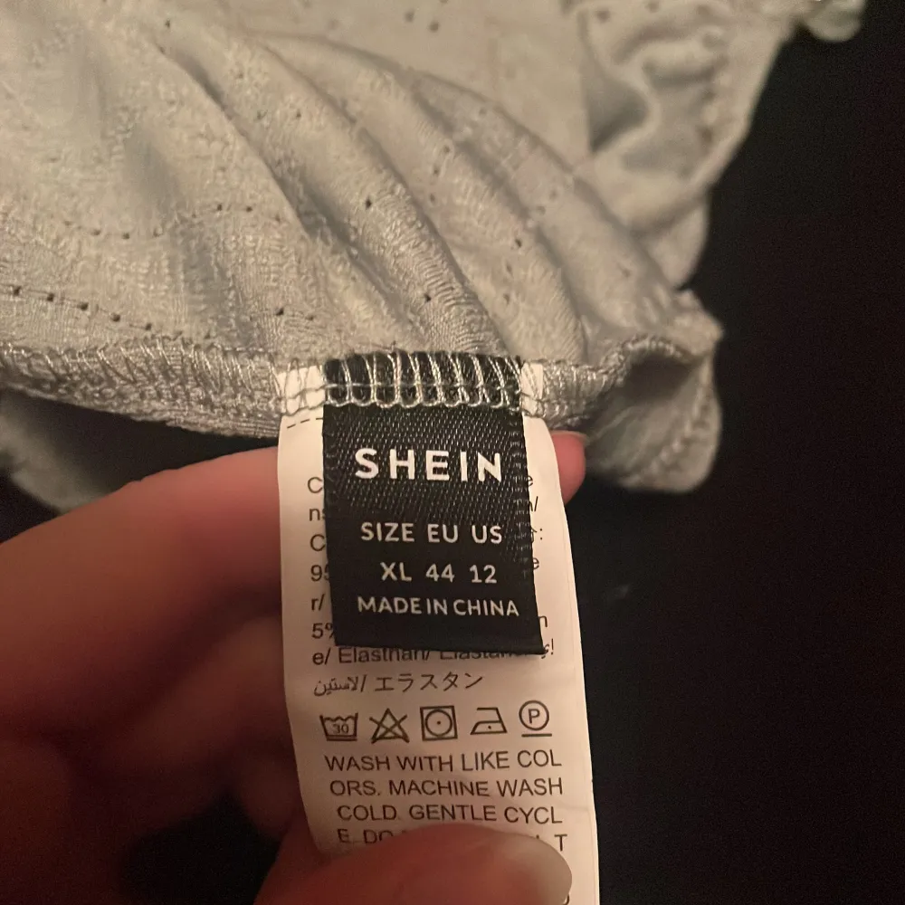 Säljer en ljusgrönt linne från Shein med broderade detaljer och knytband vid axlarna. Toppen har en luftig passform och är perfekt för varma dagar. Den är tillverkad i ett lätt och bekvämt material.. Yläosat.