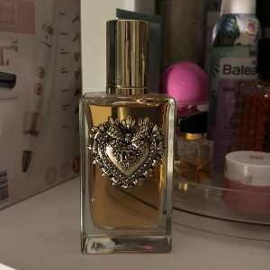 Parfym från Dolce & Gabbana - Pris kan diskuteras ! Fick i julklapp men lukten va inte ricktigt mig ! Elegant parfymflaska från Dolce & Gabbana med en lyxig design. Flaskan är rektangulär med en gyllene vätska och har ett vackert dekorerat hjärta på framsidan. Korken är i guld och ger en exklusiv känsla. Perfekt för den som vill ha en doft med stil och elegans.