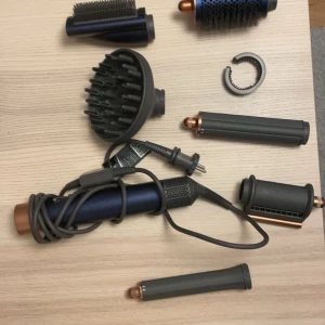 Hårstylingverktyg med tillbehör från Dyson - Säljer ett komplett hårstylingverktyg från Dyson med flera tillbehör. Inkluderar olika borsthuvuden och munstycken för varierad styling. Perfekt för att skapa volym och lockar. Har använt ca 7-10 gånger men kommer inte till användning någon mer. Värme borste munstycket har legat längst ner så lite av borstråna längst upp viker ner lite men de är inget som påverkas när man fixar håret💫Köptes för 6200kr💗pris kan diskuteras🌸