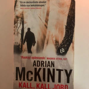 Kall, kall jord - Boken 'Kall, kall jord' av Adrian McKinty är en spännande deckare. Omslaget visar en silhuett av en person i en skog, vilket ger en mystisk och dramatisk känsla. Perfekt för dig som gillar nervkittlande läsning.
