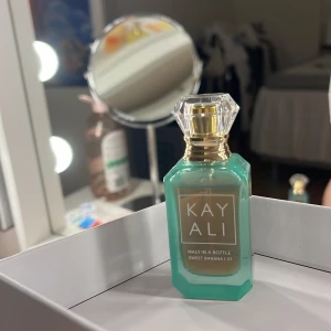 Kayali Sweet Banana  - Säljer en fräsch och exotisk parfym från Kayali, Maui in a Bottle Sweet Banana 137. Flaskan är turkos med en elegant guldfärgad kork och har en modern, stilren design. Perfekt för dig som älskar tropiska dofter! Den är endast testad. Luktar jättegott men säljer nu pga för mycket parfymer
