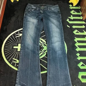 Low rise bootcut River Island jeans  - Jättefina low waist jeans från River Island som nästan aldrig blivit använda pga fel storlek. Skicket 10/10 följt av en cool tvätt med fina detaljer på bakfickorna i stretchigt material. Slitningar är gjort av symaskin. Skriv gärna om ni har frågor!!