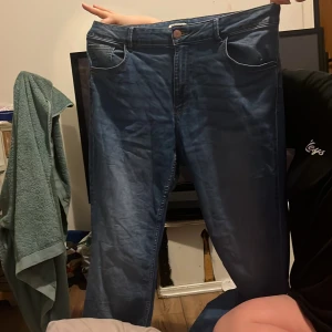 Blå jeansbyxor - Säljer ett par klassiska blå jeansbyxor med normal passform. De har en traditionell femficksdesign och knappgylf. Perfekta för en avslappnad stil.