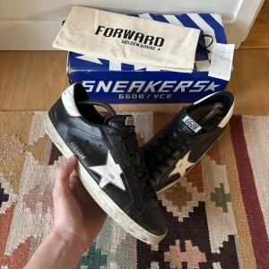 Svarta sneakers från Golden Goose - Tja! Säljer nu mina Golden Goose SuperStars i en eftertraktad färg. Sparsamt använda, självklart äkta. Storlek 43, har allt og och det ingår, Box dustbag Golden Goose kort osv. Bara att höra av dig om du vill ha fler bilder eller liknande✌️