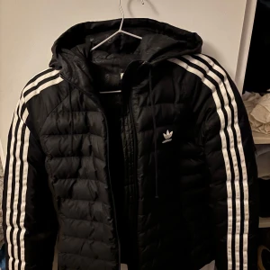 Svart dunjacka från Adidas - Adidas jacka storlek S , litet hål vid axeln 